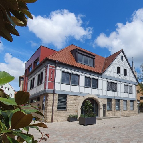 Hände mit aufgedruckter Weltkarte im Hintergrund blauer Himmel mit weißen Wolken