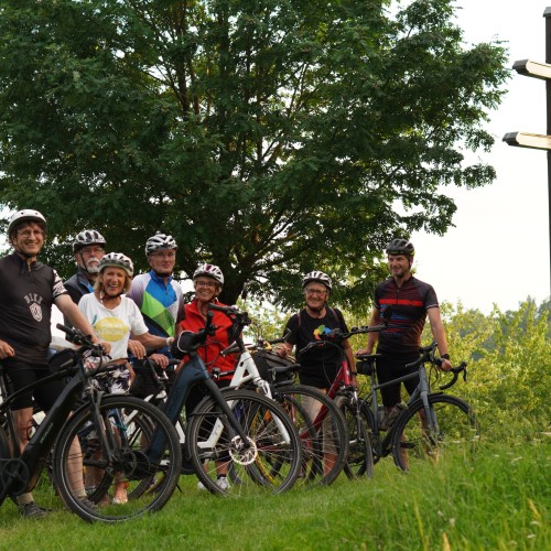 Fahrradgruppe im Hintergrund ein Baum