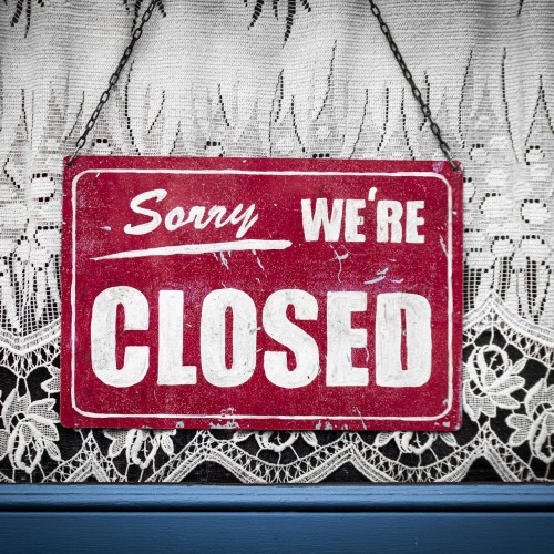 Tür Schild vor einem Spitzenvorhang "Sorry we are closed"